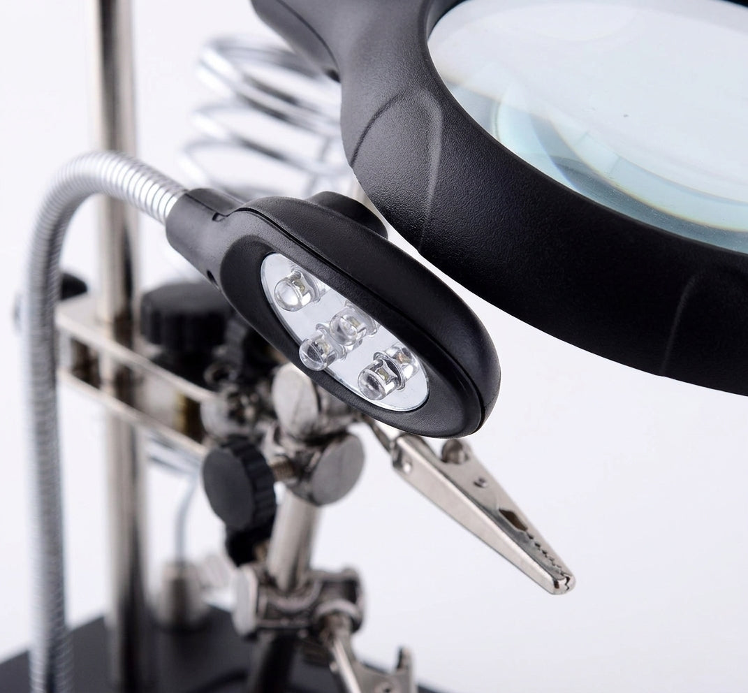 Persona reparando joyeria con lupa escritorio LED soporte articulado