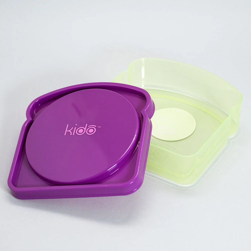 Niño abriendo porta sandwich Kido violeta en recreo colegio