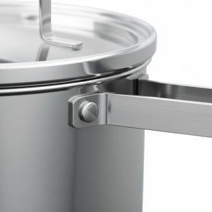 Olla cazo inoxidable con tapa escurridor sobre cocina inducción apartamento moderno