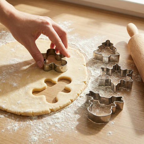 Niños cortando galletas navideñas con moldes acero inoxidable masa extendida cocina