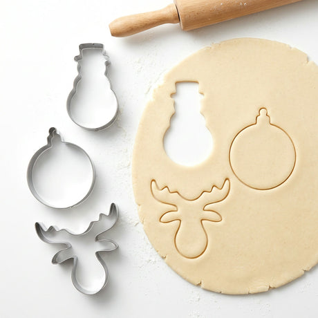 Cortadores galletas navideñas metal en uso sobre masa extendida cocina hogar