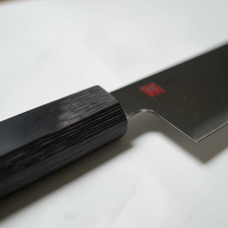 Cuchillo chef japonés Wayu en quincho chileno junto a cortes de carne asado