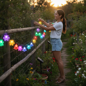 Mujer decorando jardín chileno con luces navidad solares RGB copos arbolitos