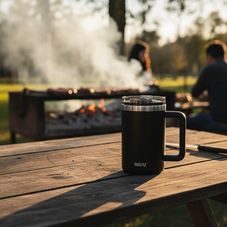Mug termico negro en asado chileno mesa rustica exterior tarde