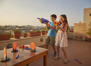 Niños jugando juego puntería dardos espuma terraza hogar chileno