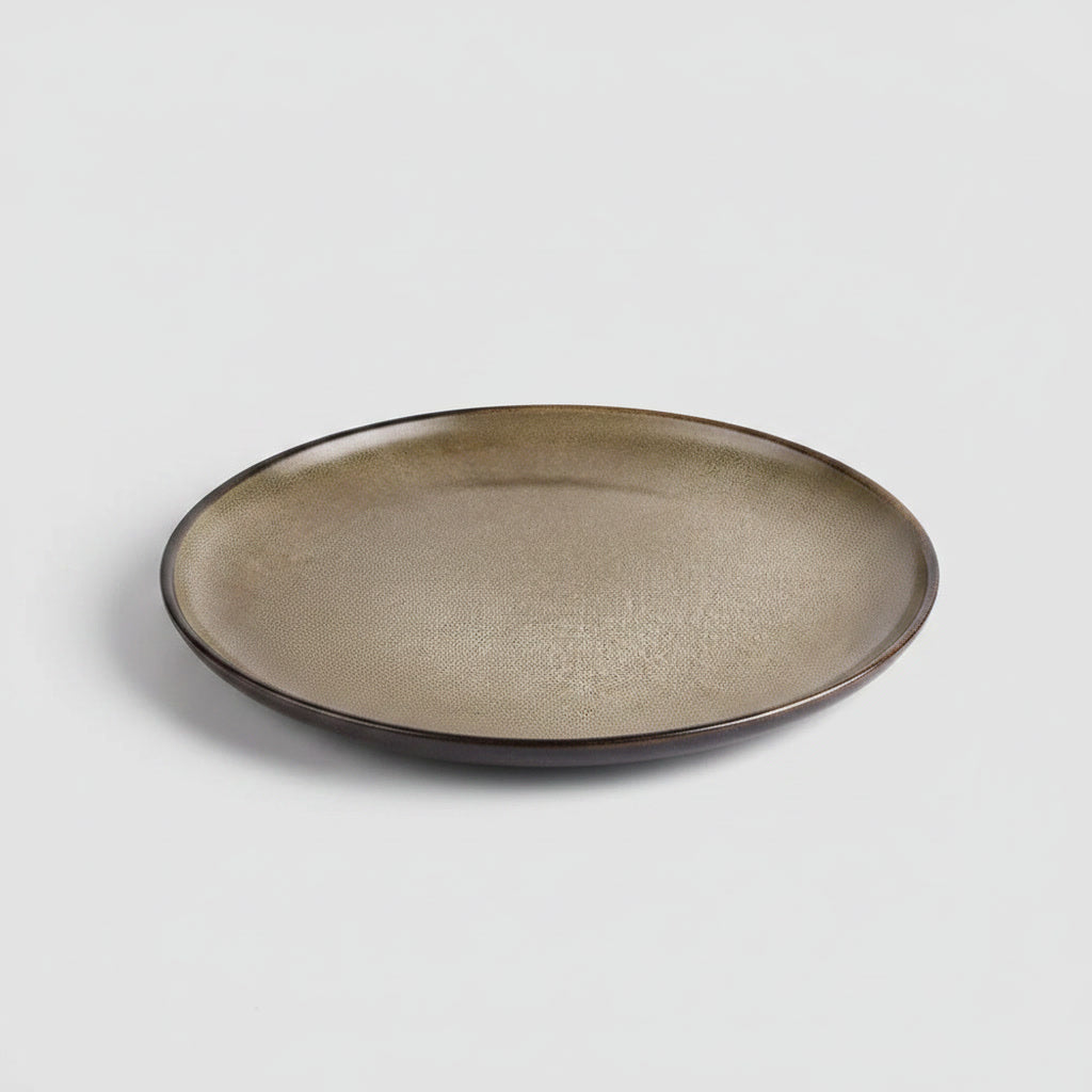 Mujer poniendo plato stoneware bronce en mesa familiar chilena
