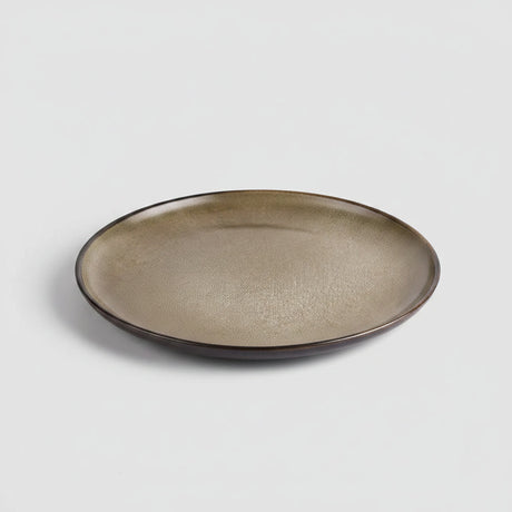 Mujer poniendo plato stoneware bronce en mesa familiar chilena