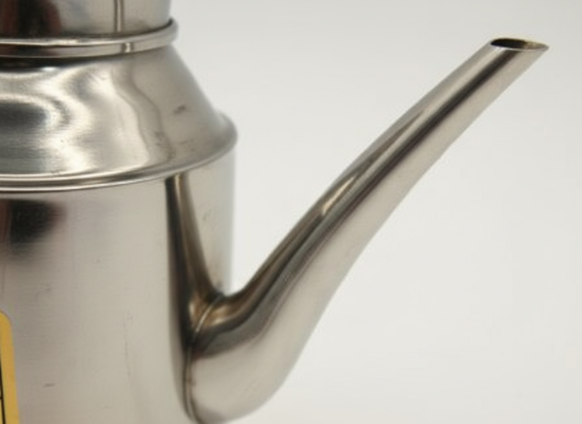Jarra acero inoxidable vertiendo té taza cerámica cocina moderna