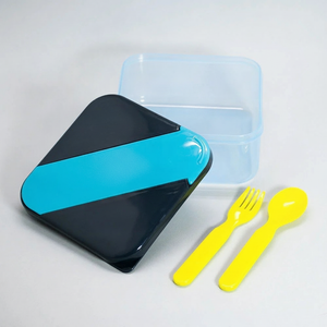 Tupper hermético Kido azul negro con cubiertos amarillos vista frontal fondo blanco